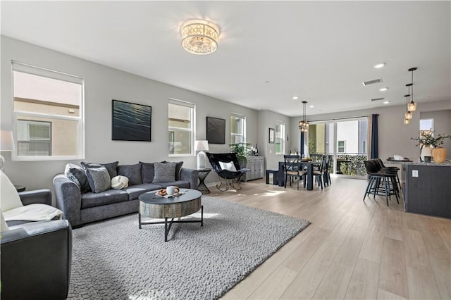 living area with light wood-type flooring, visible vents, and recessed lighting