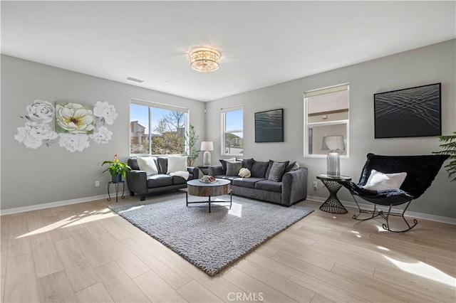 living area featuring wood finished floors, baseboards, and visible vents