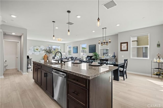 kitchen with visible vents, a sink, dark brown cabinetry, light wood-style floors, and stainless steel dishwasher