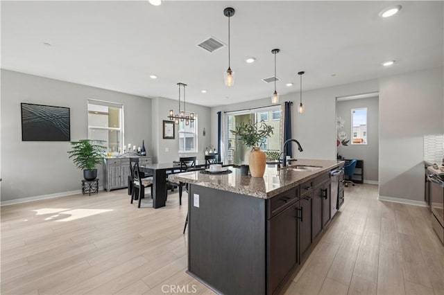 kitchen with a sink, visible vents, and light wood-style floors