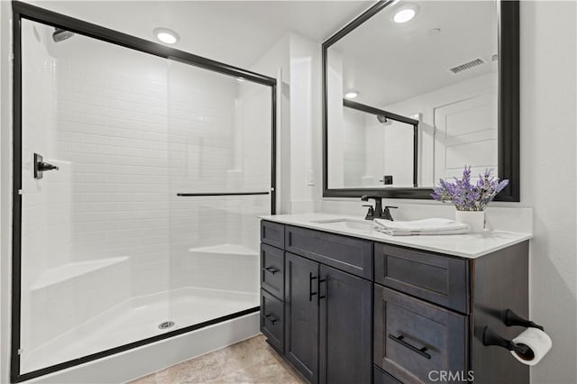 full bathroom with vanity, a shower stall, recessed lighting, and visible vents