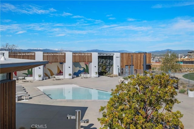pool featuring a mountain view, fence, and a patio area