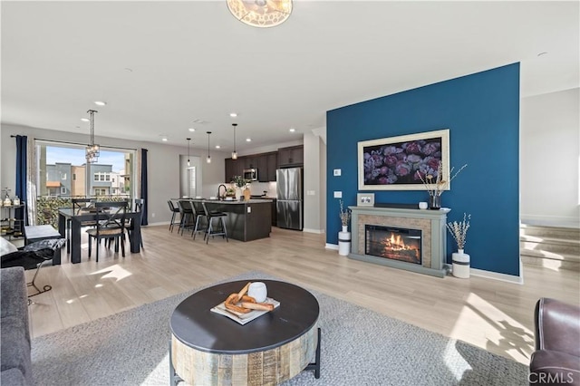 27046 Tanager Ln, Valencia, CA 91381 - living room featuring light wood finished floors, recessed lighting, and a glass covered fireplace