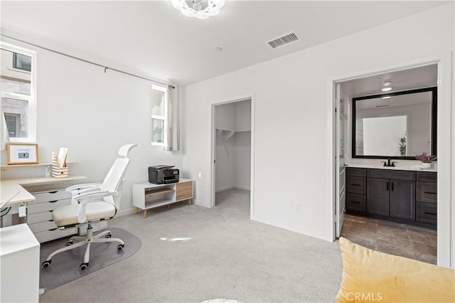 home office featuring baseboards, light colored carpet, visible vents, and a sink