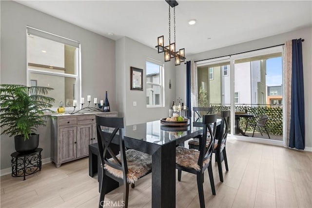 dining area with a healthy amount of sunlight, light wood finished floors, an inviting chandelier, and recessed lighting