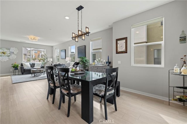 dining area featuring light wood finished floors and baseboards