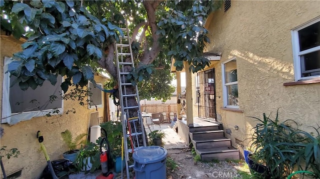 exterior space with stucco siding and fence