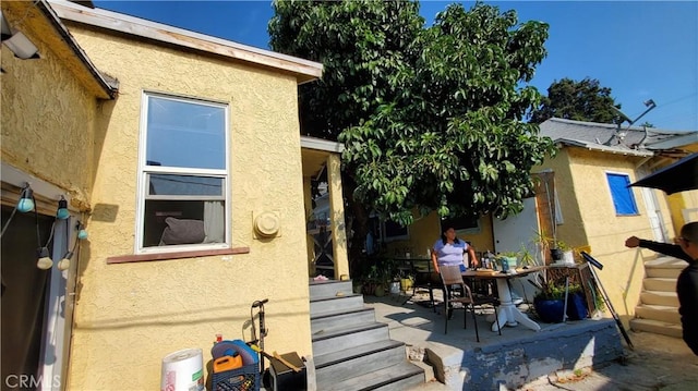 back of property with a patio area and stucco siding