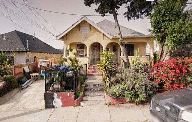 view of front of home featuring fence and covered porch