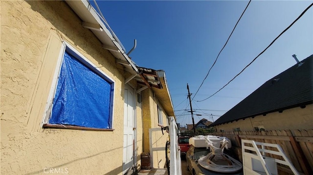 view of property exterior featuring stucco siding and fence