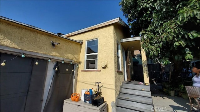 view of home's exterior with stucco siding and a garage