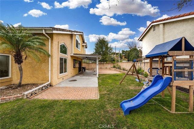 view of yard featuring a fenced backyard, a playground, and a patio