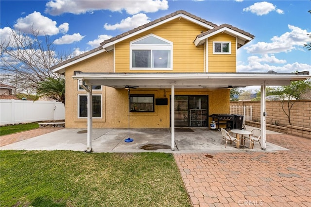 back of house with a yard, a fenced backyard, stucco siding, and a patio area