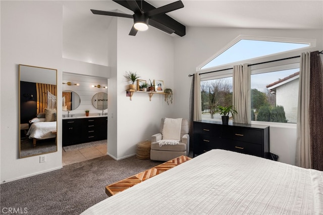 bedroom with high vaulted ceiling, a ceiling fan, ensuite bath, baseboards, and light colored carpet