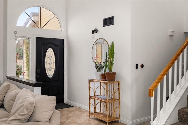 entryway featuring stairs, light tile patterned floors, baseboards, and visible vents