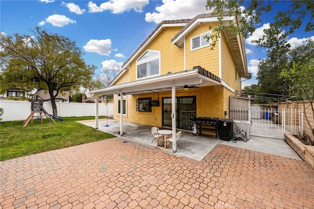 rear view of house featuring a patio, a yard, a fenced backyard, french doors, and a playground