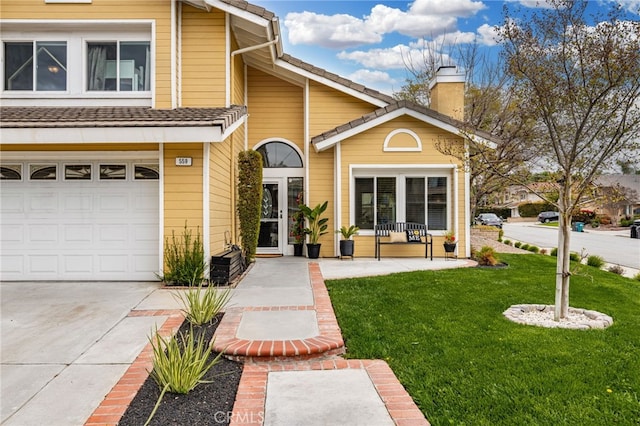 view of front of home with a front yard, an attached garage, driveway, and a chimney