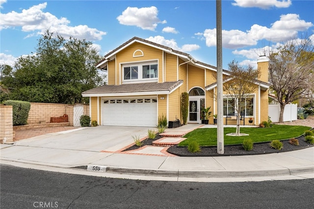 traditional-style house with a front lawn, fence, concrete driveway, a chimney, and a garage