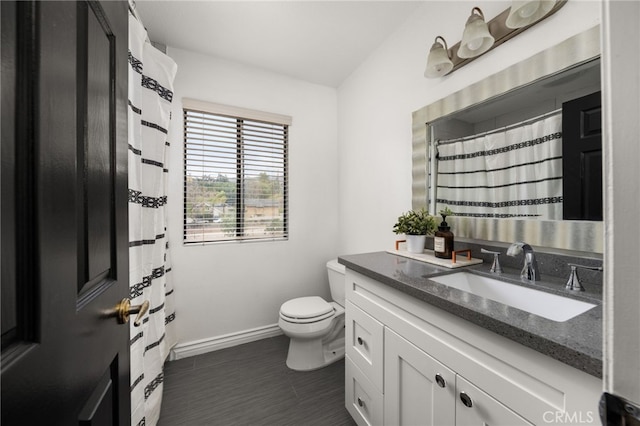 bathroom featuring vanity, toilet, and baseboards