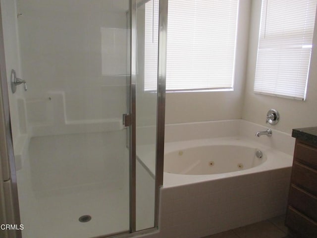 bathroom featuring vanity, tile patterned floors, a tub with jets, and a stall shower