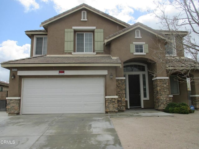 view of front of house featuring stucco siding, stone siding, concrete driveway, an attached garage, and a tiled roof