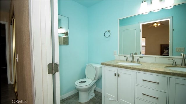 bathroom with double vanity, tile patterned flooring, toilet, and a sink