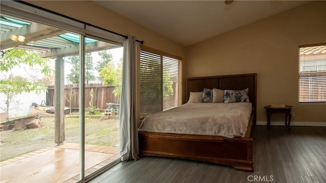 bedroom with vaulted ceiling, wood finished floors, baseboards, and access to outside