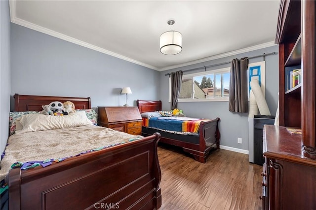 bedroom with crown molding, baseboards, and wood finished floors