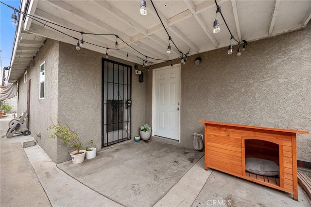 property entrance with a patio and stucco siding