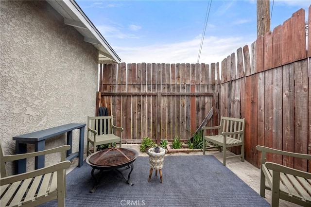 view of patio with a fire pit and fence