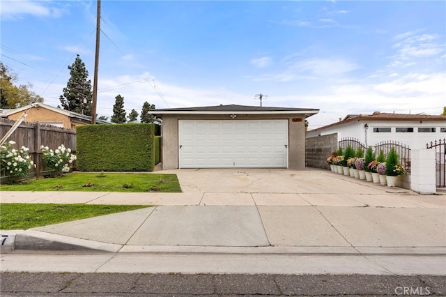 view of front facade with stucco siding, an outdoor structure, a garage, and fence