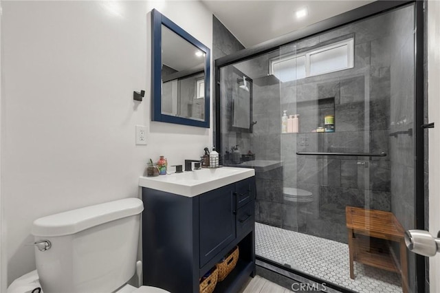 full bath featuring a stall shower, toilet, and vanity