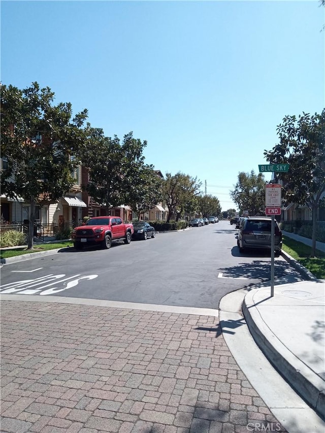 view of road with traffic signs, curbs, and sidewalks