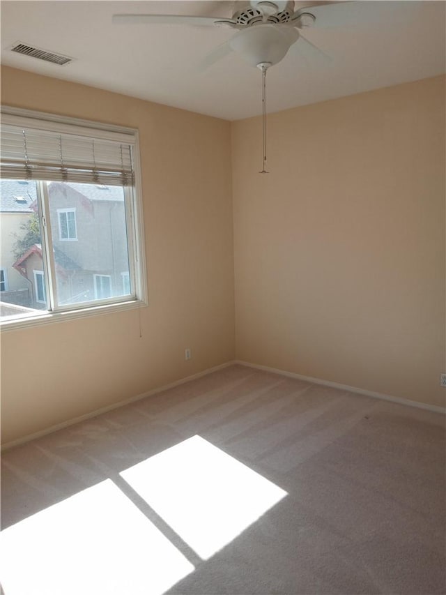 empty room with visible vents, light carpet, and baseboards