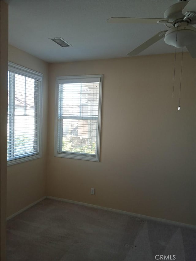 spare room with visible vents, baseboards, a ceiling fan, and carpet flooring