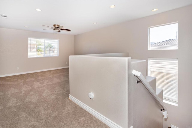 hall with recessed lighting, baseboards, an upstairs landing, and light colored carpet