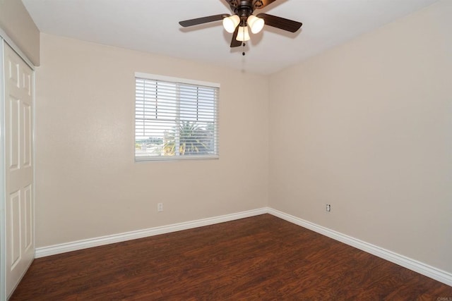 unfurnished bedroom with ceiling fan, a closet, baseboards, and dark wood-style floors