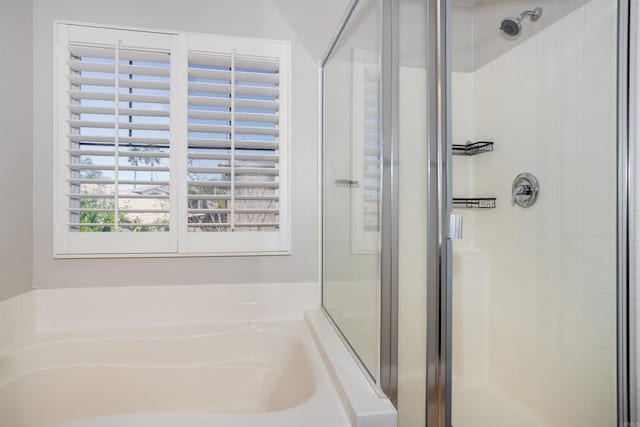 bathroom with a shower stall and a bath