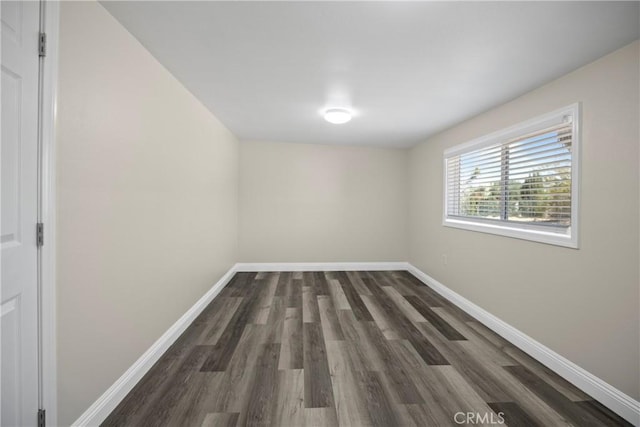 unfurnished room with baseboards and wood finished floors