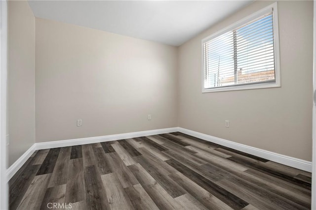 unfurnished room with dark wood-style floors and baseboards