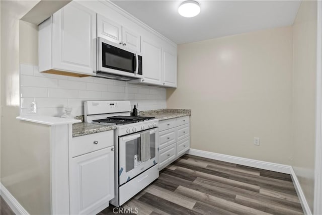 kitchen with white appliances, dark wood-style floors, baseboards, white cabinets, and backsplash