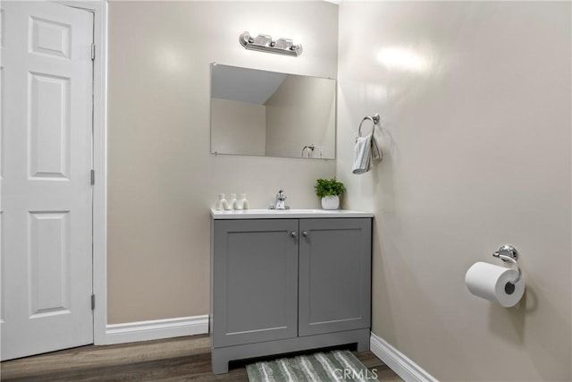 bathroom with vanity, baseboards, and wood finished floors