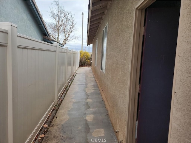 view of side of property with fence and stucco siding