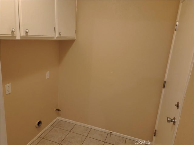 laundry room with light tile patterned floors, baseboards, and cabinet space