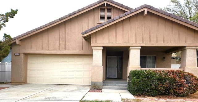 view of front of property featuring a garage, concrete driveway, stucco siding, and a tile roof