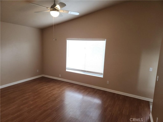 unfurnished room with baseboards, lofted ceiling, and dark wood-style flooring