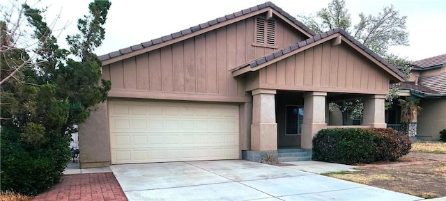 view of front of home featuring a tiled roof, driveway, and stucco siding