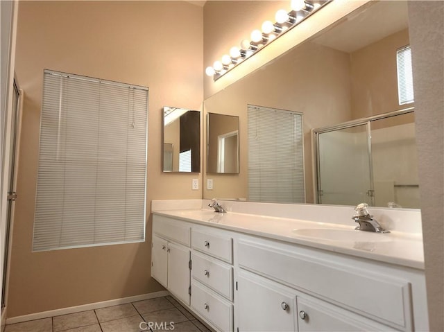 bathroom with tile patterned flooring, double vanity, a stall shower, and a sink