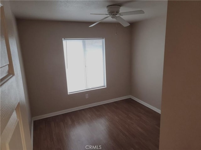 unfurnished room featuring a ceiling fan, baseboards, and wood finished floors