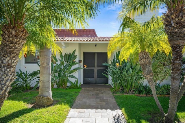 property entrance with stucco siding and a tiled roof